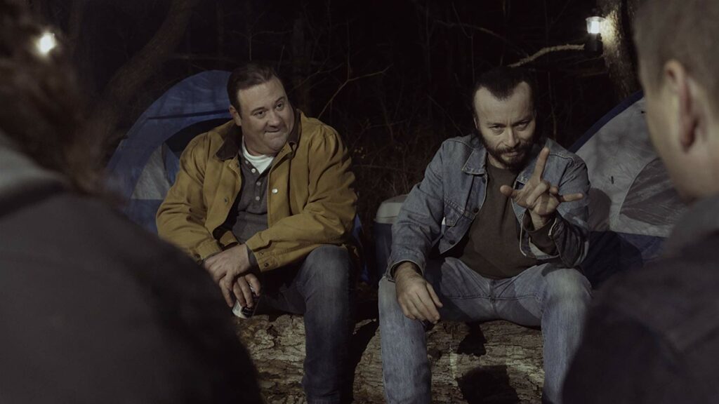Vinny Blade (Billy Blair) and Drew (Jason P. Kendall) chat with other partygoers around the campfire at <i>Cherokee Creek</i>